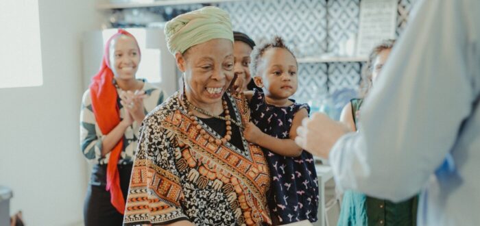 A lady smiling while holding a baby