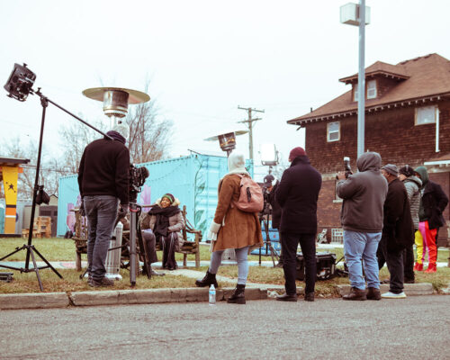 Soulidarity members talk to media outside, next to a new solar powered street lamp