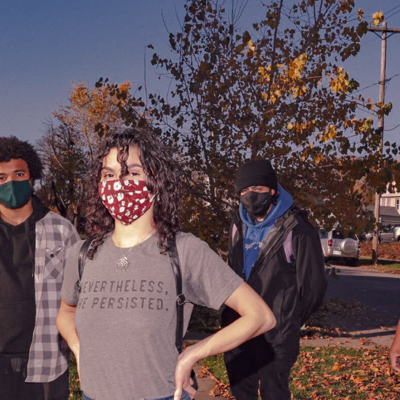 Three people in masks look challengingly at the camera