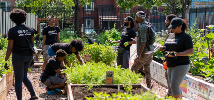 Group of people laughing and working in the Good Life Community Garden