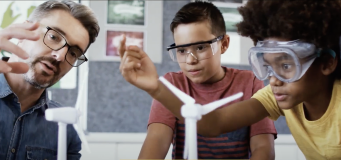 kids gathered around model wind turbines