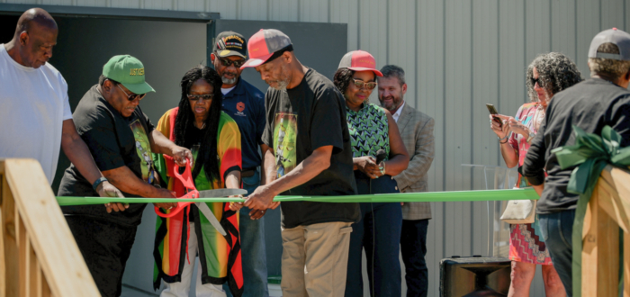 Photo of ribbon cutting ceremony with Rev Woodberry of New Alpha CDC