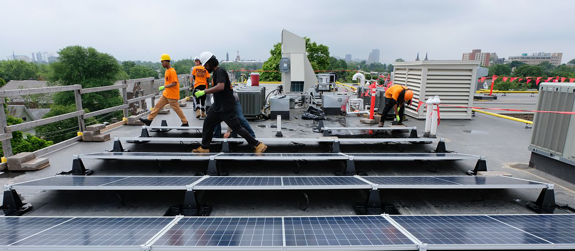 Group of people on roof installing solar panels